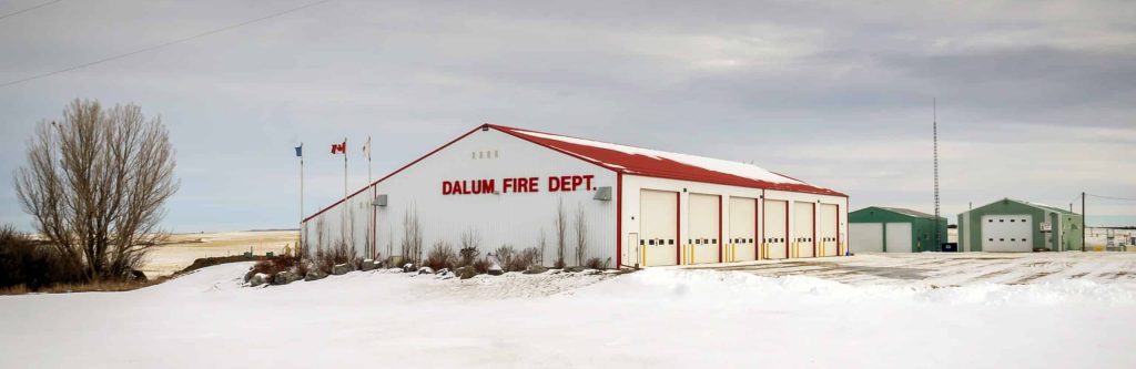 A bright white post-frame commercial building with 10 overhead doors