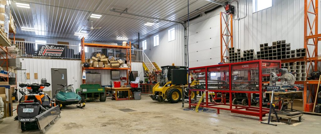 A charcoal post-frame commercial shop with an overhead door