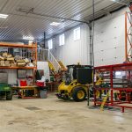 A charcoal post-frame commercial shop with an overhead door