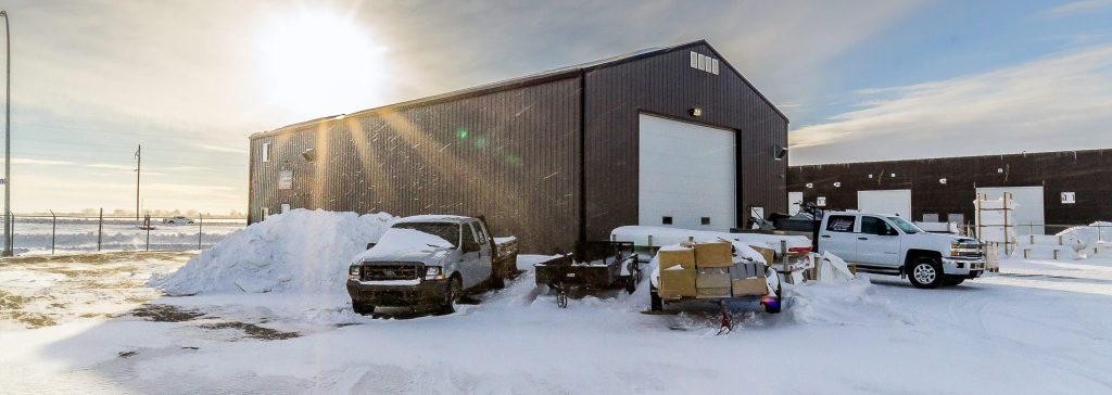 A charcoal post-frame commercial shop with an overhead door
