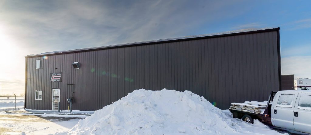 A charcoal post-frame commercial shop with an overhead door