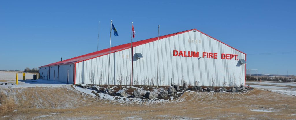 A bright white post-frame commercial building with 10 overhead doors