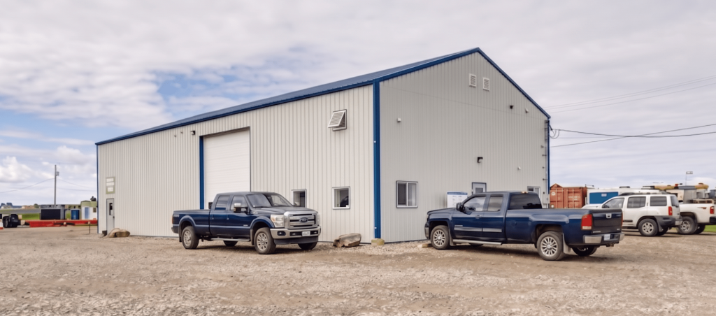 A bone white post-frame commercial shop with heron blue exterior trims