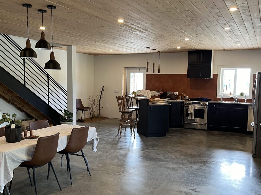 A bright white post-frame Residential Shouse with soffits and an overhead door