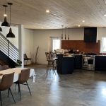 A bright white post-frame Residential Shouse with soffits and an overhead door