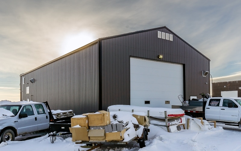 A charcoal post-frame commercial shop with an overhead door