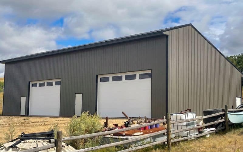 A charcoal post-frame agriculture storage with overhead doors