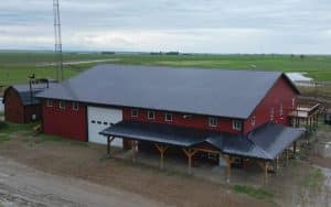 A dark red post-frame agriculture storage shop