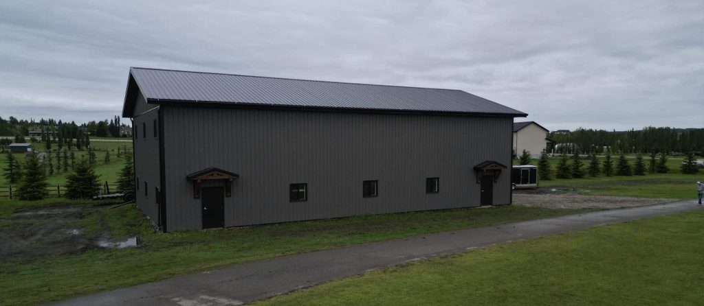 A post-frame commercial storage building with premium Frontier metal cladding and black overhead doors