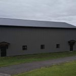 A post-frame commercial storage building with premium Frontier metal cladding and black overhead doors
