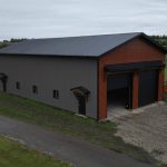 A post-frame commercial storage building with premium Frontier metal cladding and black overhead doors