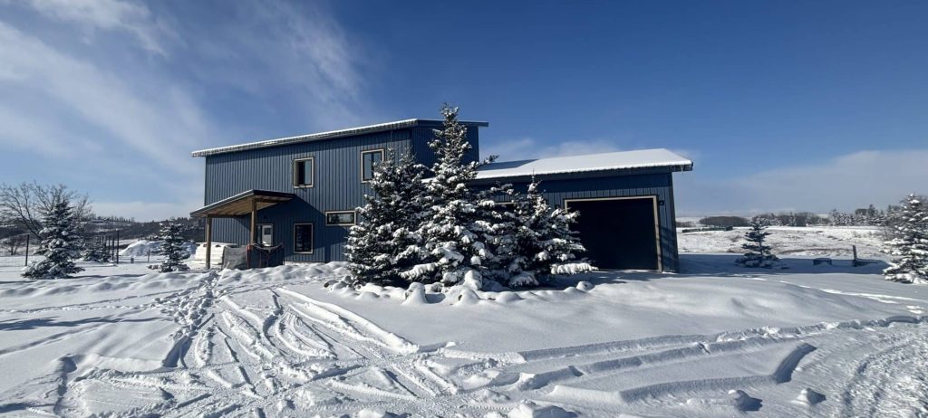 A blue bird post-frame prairie Peak residential home