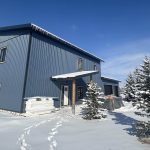 A blue bird post-frame prairie Peak residential home