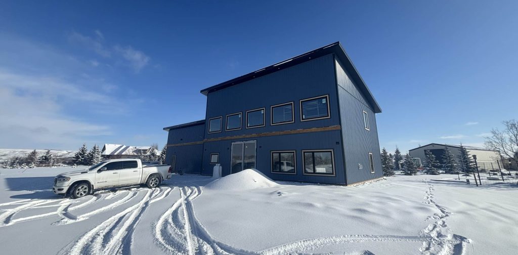 A blue bird post-frame prairie Peak residential home