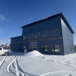 A blue bird post-frame prairie Peak residential home
