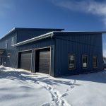 A blue bird post-frame prairie Peak residential home