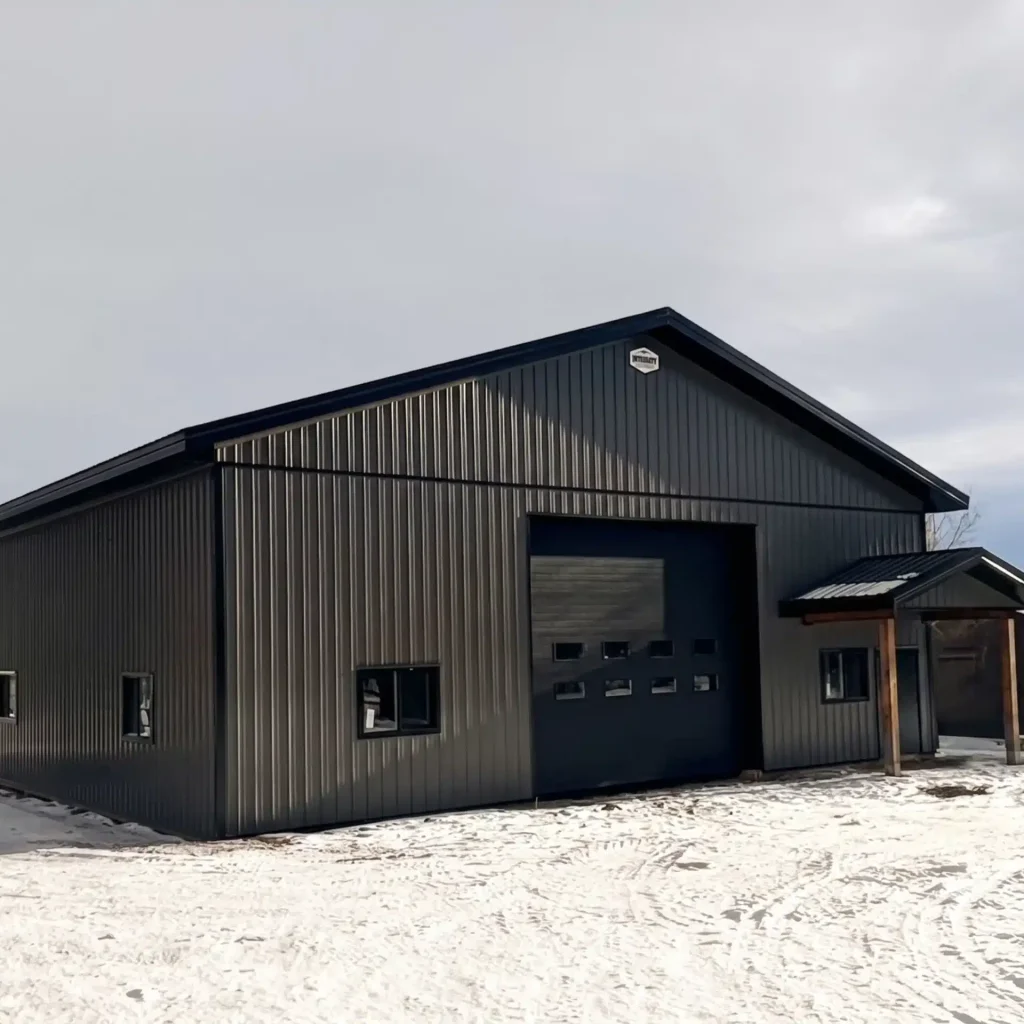 A charcoal post-frame lifestyle and agricultural shop with open lean-to porch, and an overhead door