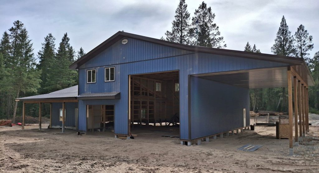 A bluebird post-frame custom residential suite with a garage and open lean-to