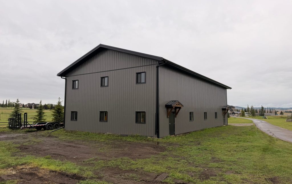 A post-frame commercial storage building with premium Frontier metal cladding and black overhead doors