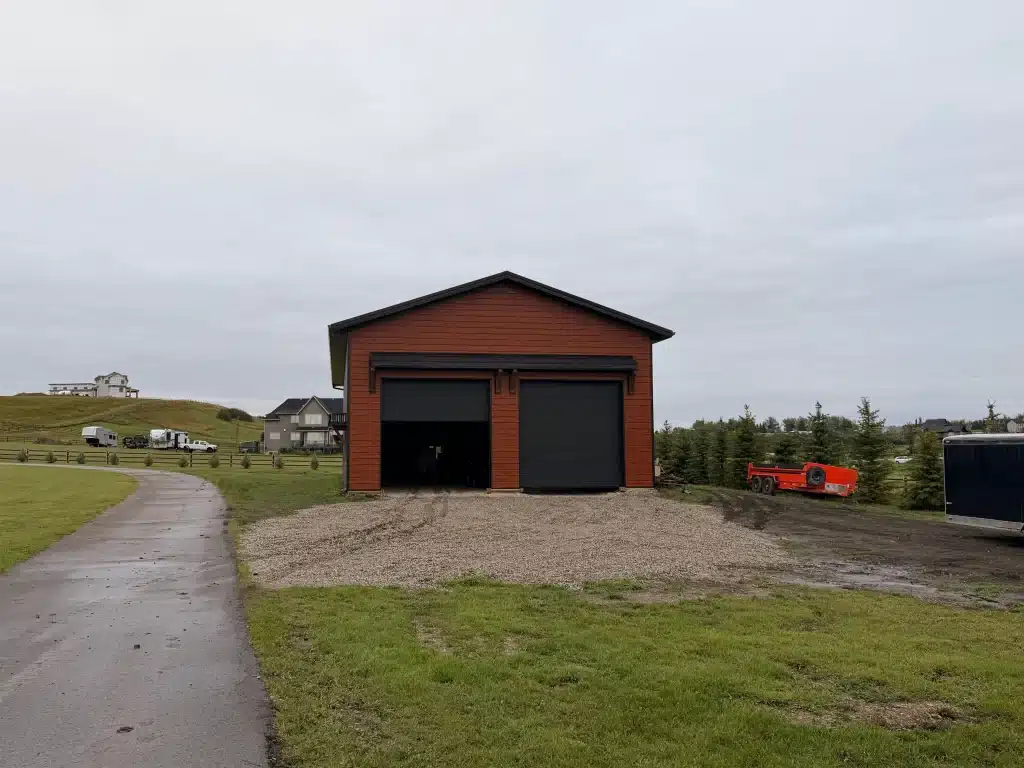 A post-frame commercial storage building with premium Frontier metal cladding and black overhead doors