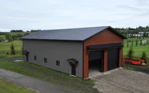 A post-frame commercial storage building with premium Frontier metal cladding and black overhead doors