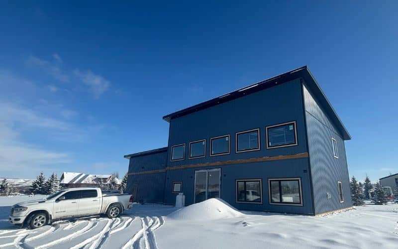 A blue bird post-frame prairie Peak residential home