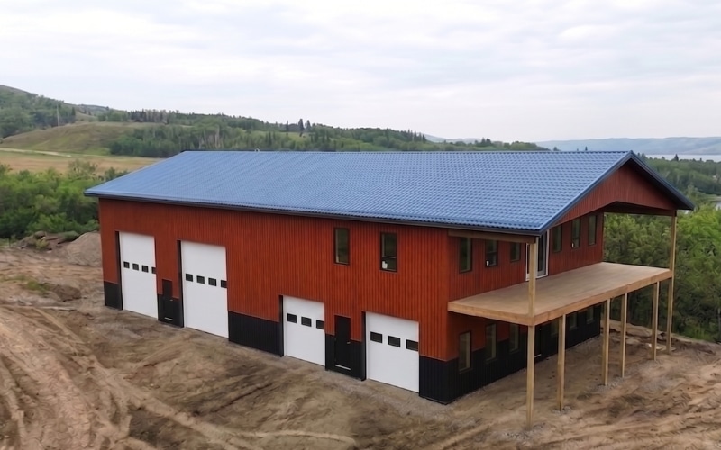 A post-frame commercial shop built with Frontier woodgrain premium metal, wainscoting, and a covered deck