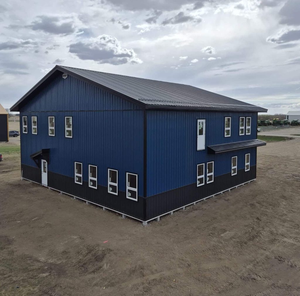 A heron blue post-frame commercial office with soffits, wainscoting, and a front porch