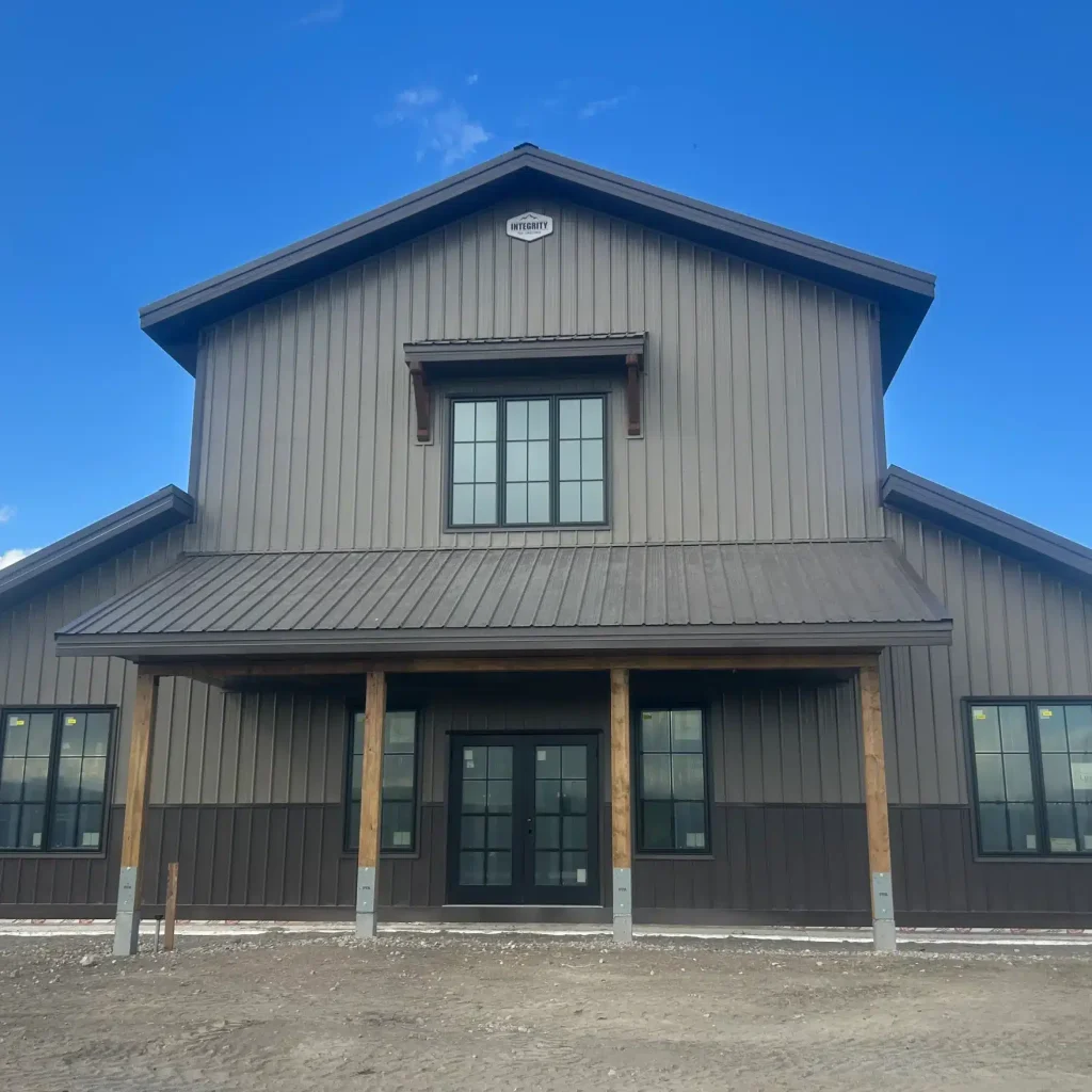 A post-frame residential barndominium with buckskin walls and coffee brown wainscoting