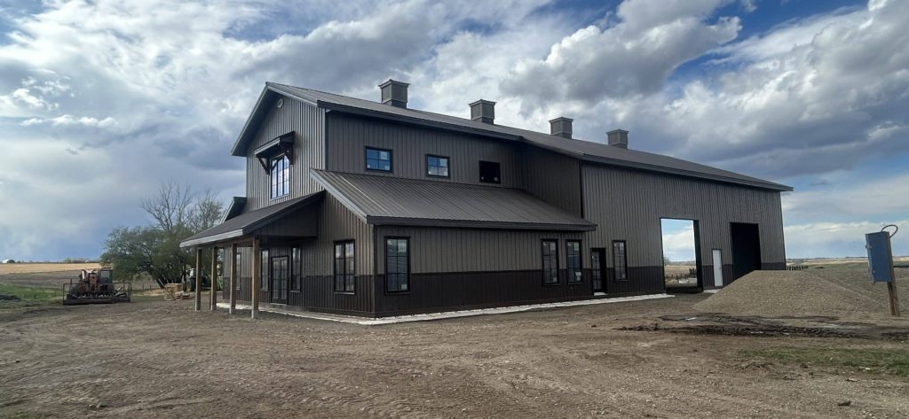 A post-frame residential barndominium with buckskin walls and coffee brown wainscoting