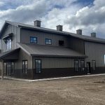 A post-frame residential barndominium with buckskin walls and coffee brown wainscoting