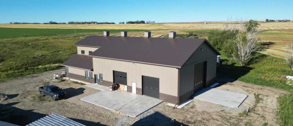 A post-frame residential barndominium with buckskin walls and coffee brown wainscoting