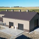 A post-frame residential barndominium with buckskin walls and coffee brown wainscoting