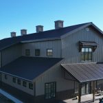 A post-frame residential barndominium with buckskin walls and coffee brown wainscoting
