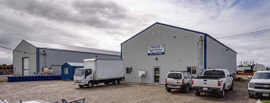 A bone white post-frame commercial shop with heron blue exterior trims