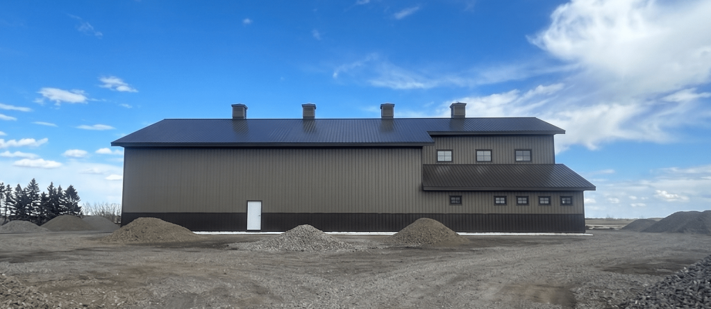 A post-frame residential barndominium with buckskin walls and coffee brown wainscoting