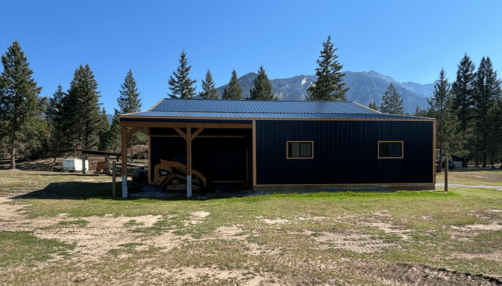 A black post-frame shop with copper penny trims and an overhead door