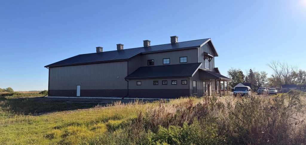 A post-frame residential barndominium with buckskin walls and coffee brown wainscoting