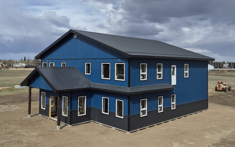 A heron blue post-frame commercial office with soffits, wainscoting, and a front porch