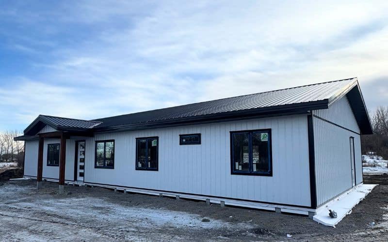 A bright white post-frame Residential Bunkhouse with a front lean-to and soffits