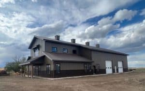 A post-frame residential barndominium with buckskin walls and coffee brown wainscoting