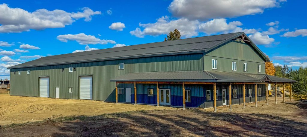 Post-frame residential building - The Shouse in greed metal cladding and a wrap-around porch in Saskatchewan