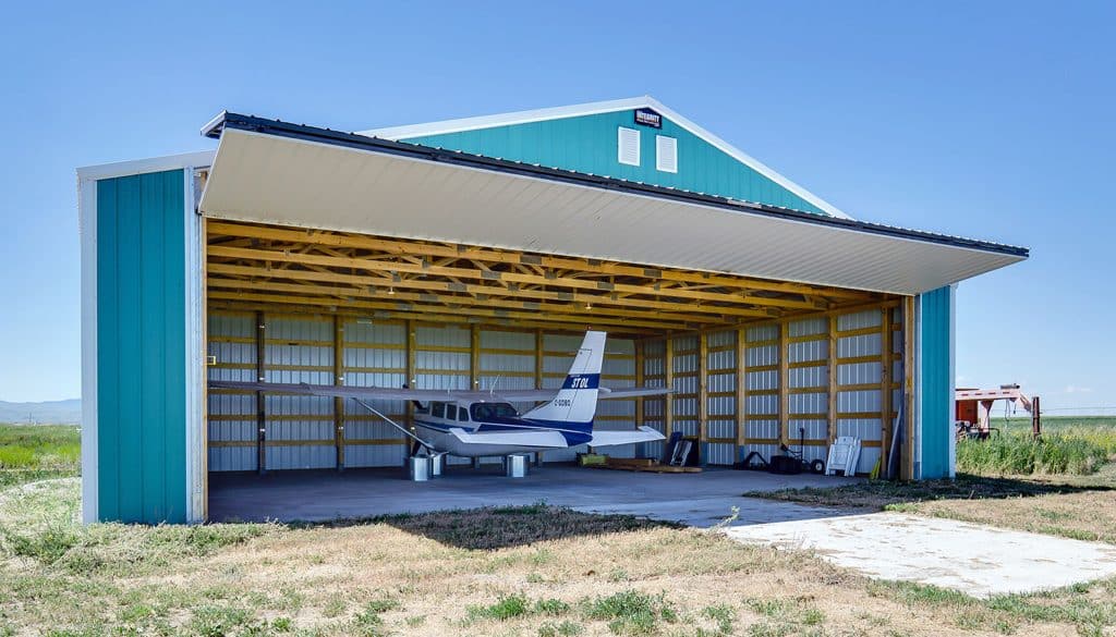 Teal post-frame airplane hangar built by Integrity Post Structures