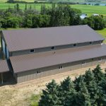A Buckskin post-frame agriculture building with a bi-fold and overhead doors