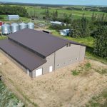 A Buckskin post-frame agriculture building with a bi-fold and overhead doors