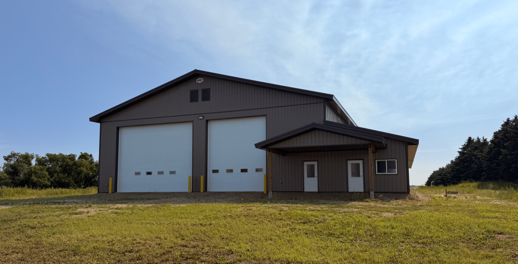A Buckskin post-frame agriculture building with a bi-fold and overhead doors