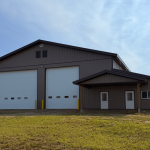 A Buckskin post-frame agriculture building with a bi-fold and overhead doors
