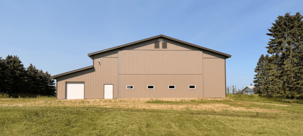 A Buckskin post-frame agriculture building with a bi-fold and overhead doors