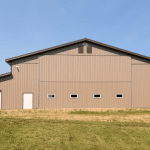 A Buckskin post-frame agriculture building with a bi-fold and overhead doors
