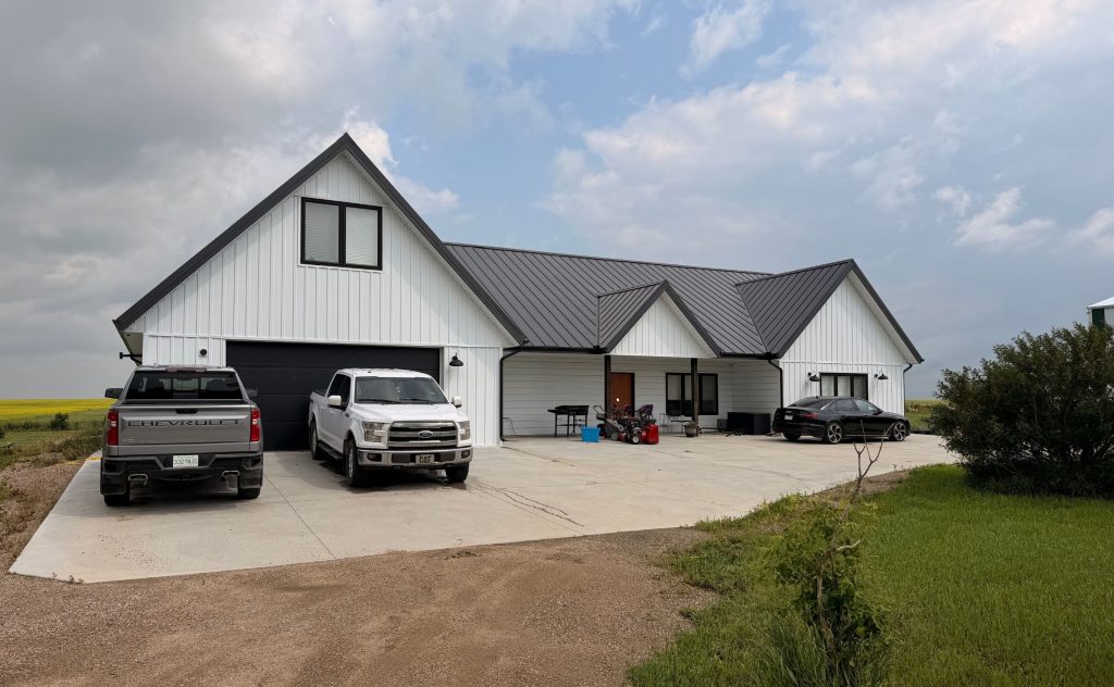 Explore the custom Homestead with loft built for Tyler near Kindersley, SK. Features upgraded Board and Batten Bright White siding and a functional, high-capacity design.